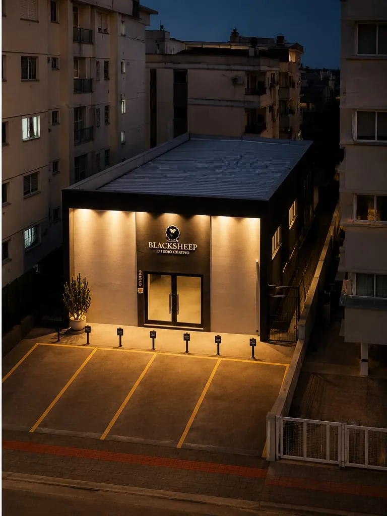 Vista aérea do Estúdio Sabrina Pierri em Palhoça, na Grande Florianópolis, com fachada iluminada e estacionamento próprio
